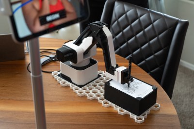 Robotic arm drawing a caricature full view